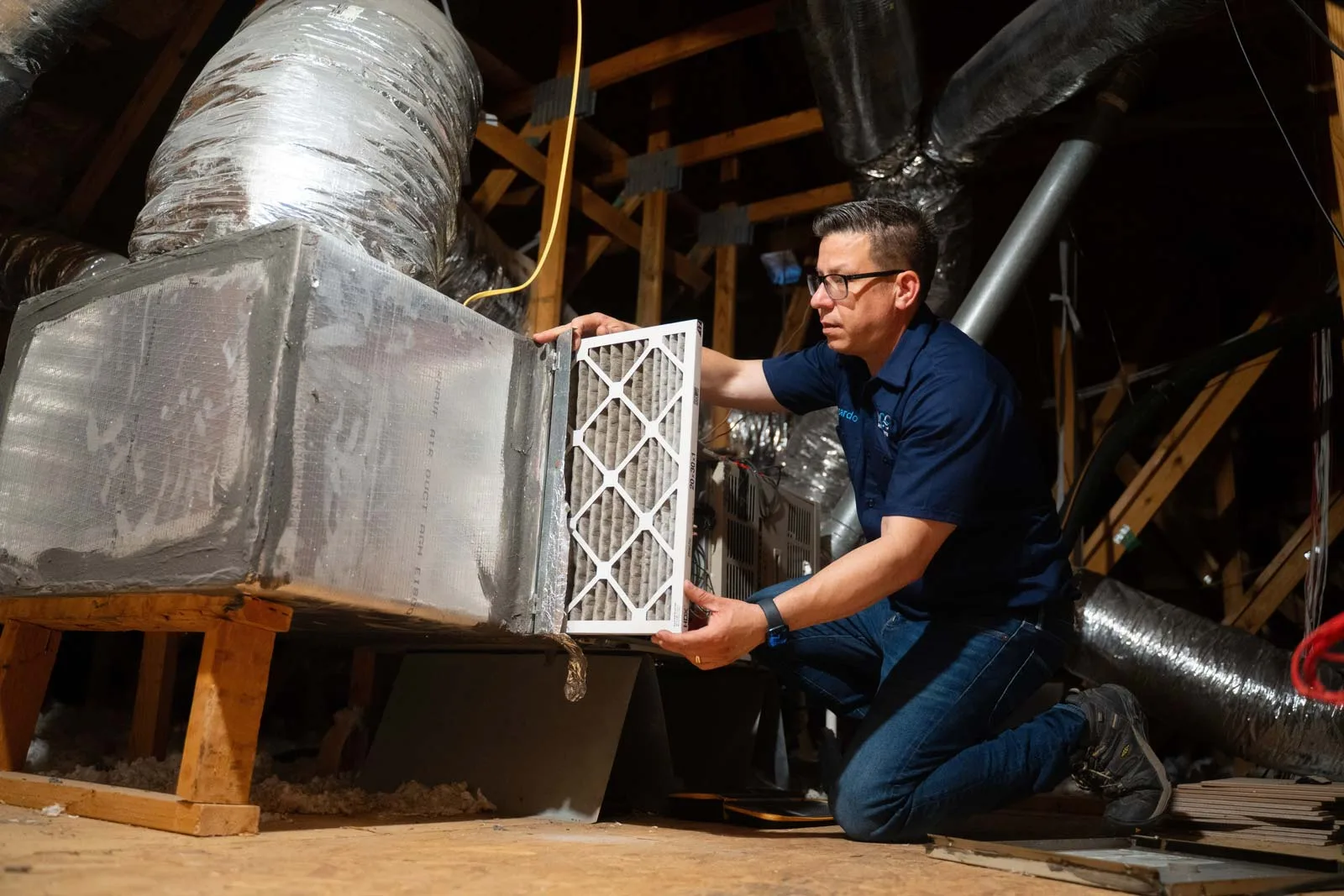 HVAC maintenance service technician inspecting unit in Houston TX